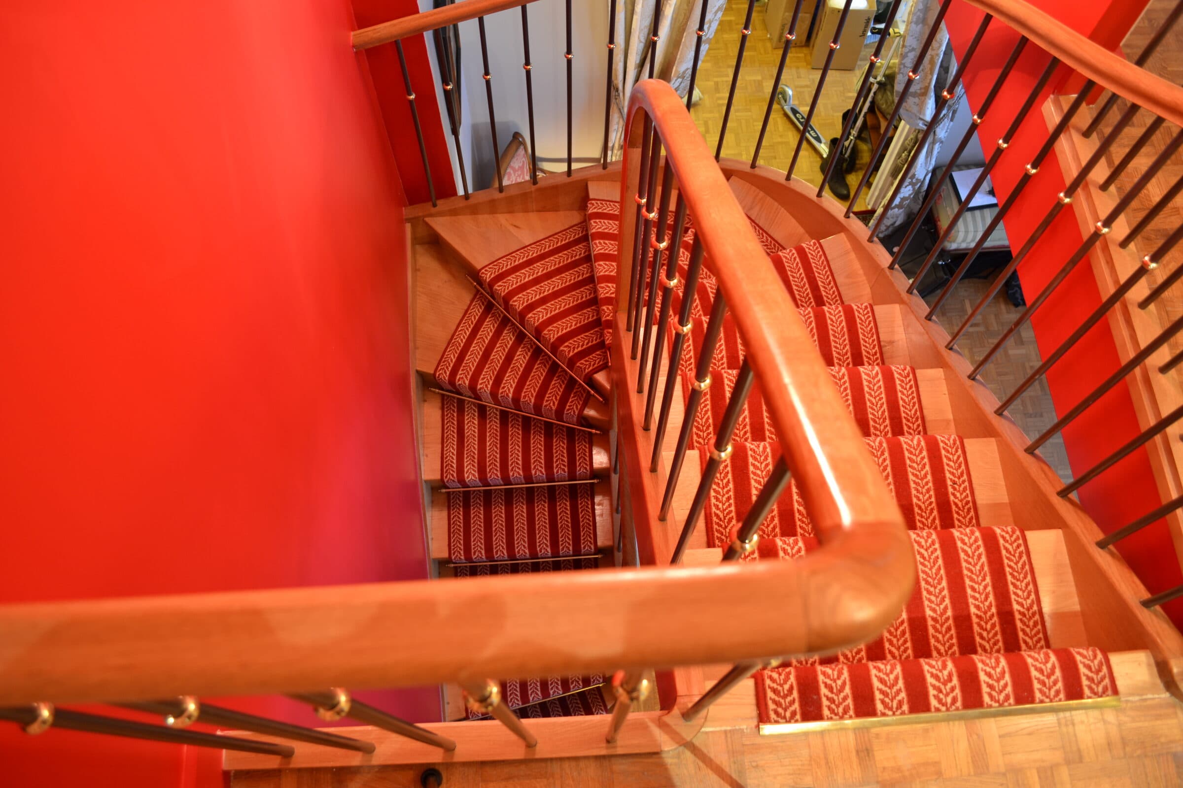 Escalier en colimaçon habillé d'un tapis rouge, vue plongeante